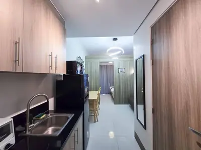 a kitchen with a sink and a kitchen with a hallway at 1BR Condotel with Balcony at FAME Residences #FM31 in Manila