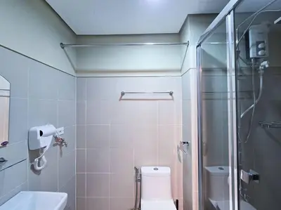 a bathroom with a shower and a toilet and a sink at 1BR Condotel with Balcony at FAME Residences #FM31 in Manila