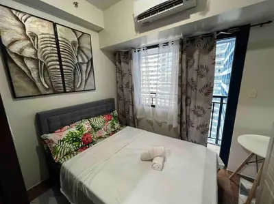 a bedroom with a bed with a towel on it at AIR Residences - 1 Bedroom Unit with Wifi and Netflix in Manila