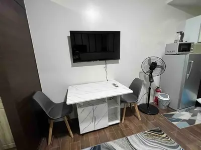 a room with a table and two chairs and a television at AIR Residences - 1 Bedroom Unit with Wifi and Netflix in Manila