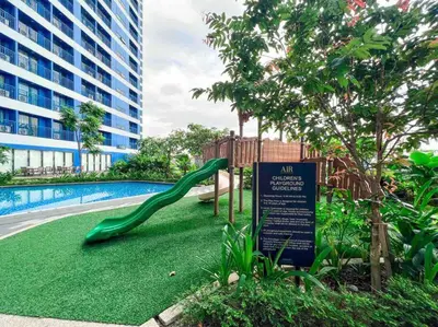 a playground with a slide next to a swimming pool at AIR Residences - 1 Bedroom Unit with Wifi and Netflix in Manila