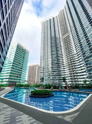 a large building with a pool in front of it at AIR Residences - 1 Bedroom Unit with Wifi and Netflix in Manila