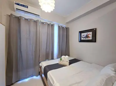 a hospital room with two beds and a window at 1BR Condotel with Balcony at FAME Residences #FM32 in Manila