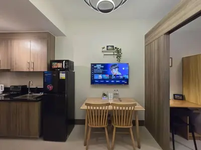 a kitchen with a small table and a black refrigerator at 1BR Condotel with Balcony at FAME Residences #FM33 in Manila