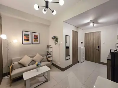 a living room with a couch and a table at 1BR Condotel with Balcony at FAME Residences #FM34 in Manila
