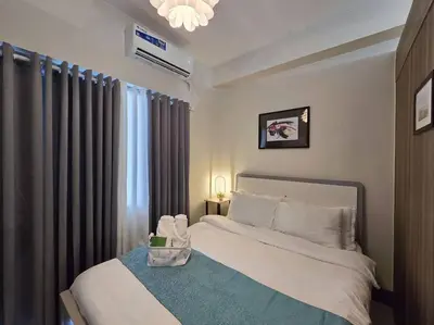 a bedroom with a white bed and a window at 1BR Condotel with Balcony at FAME Residences #FM34 in Manila