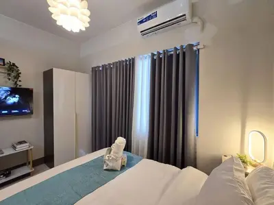 a bedroom with a white bed and a television at 1BR Condotel with Balcony at FAME Residences #FM34 in Manila