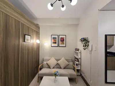 a living room with a couch and a table at 1BR Condotel with Balcony at FAME Residences #FM34 in Manila