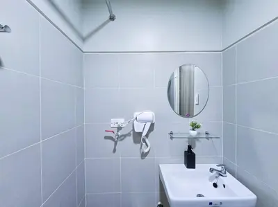 a white bathroom with a sink and a mirror at 1BR Condotel with Balcony at FAME Residences #FM38 in Manila