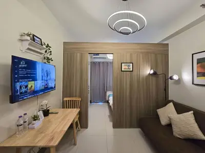 a living room with a couch and a table and a tv at 1BR Condotel with Balcony at FAME Residences #FM39 in Manila