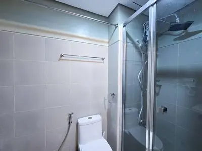 a bathroom with a toilet and a glass shower at 1BR Condotel with Balcony at FAME Residences #FM39 in Manila