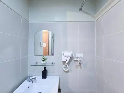 a white bathroom with a sink and a mirror at 1BR Condotel with Balcony at FAME Residences #FM39 in Manila