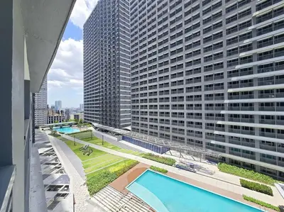 an overhead view of a large building with a swimming pool at 1BR Condotel with Balcony at FAME Residences #FM39 in Manila