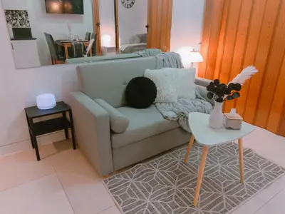 a living room with a couch and a table at Bright & Airy Studio near Venice Mall with Pool, Gym & Fast WiFi in Manila