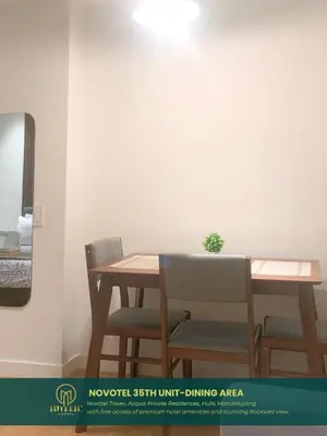 a wooden table and chairs with a plant on it at Novotel Tower at Mandaluyong Rockwell View in Manila