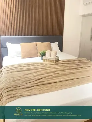 a bedroom with a bed with white sheets and pillows at Novotel Tower at Mandaluyong Rockwell View in Manila