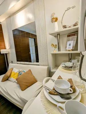 a living room with a white couch and a table at Sun and Moon cozywhite Air Residences Makati in Manila