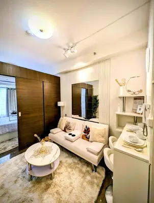 a living room with a couch and a table at Sun and Moon cozywhite Air Residences Makati in Manila