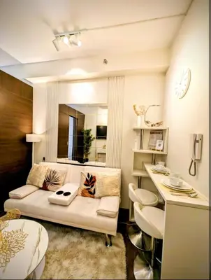 a living room with a couch and a table at Sun and Moon cozywhite Air Residences Makati in Manila
