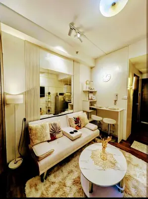 a living room with a couch and a table at Sun and Moon cozywhite Air Residences Makati in Manila