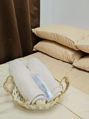 a wicker basket with a thermometer sitting on a bed at Bubu and son suites staycation beside enchanted kingdom in Santa Rosa