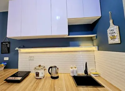 a kitchen with white cabinets and a counter top at Bubu and son suites staycation beside enchanted kingdom in Santa Rosa