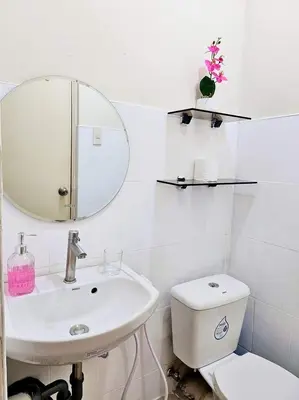 a bathroom with a sink and a toilet and a mirror at Bubu and son suites staycation beside enchanted kingdom in Santa Rosa