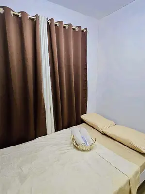 a bedroom with a bed with two phones on it at Bubu and son suites staycation beside enchanted kingdom in Santa Rosa