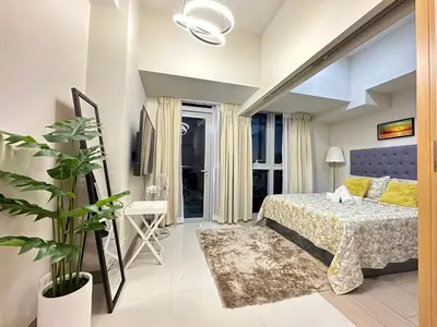 a bedroom with a bed and a plant at Relax and Unwind at Uptown BGC in Manila