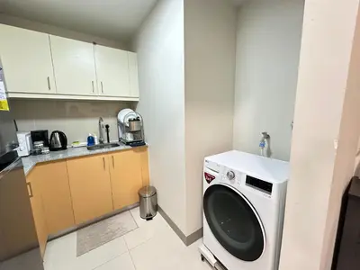 a small kitchen with a washing machine in it at Relax and Unwind at Uptown BGC in Manila