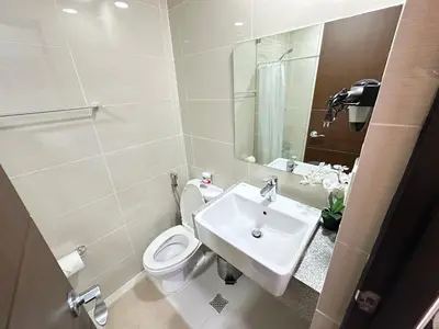 a bathroom with a sink and a toilet and a mirror at Relax and Unwind at Uptown BGC in Manila
