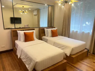 two beds in a hotel room with a mirror at Makati Medical City Accommodation in Manila