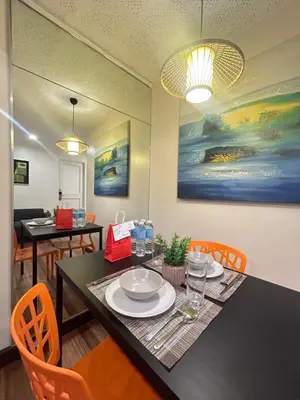 a dining room with a black table and orange chairs at Makati Medical City Accommodation in Manila