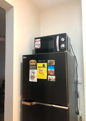 a refrigerator with a microwave on top of it at Uptown Parksuites BGC with Balcony in Manila