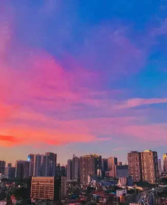 a view of a city with a pink sky at Uptown Parksuites BGC with Balcony in Manila