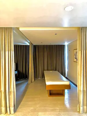 a room with a bench in a room with curtains at Uptown Parksuites BGC with Balcony in Manila