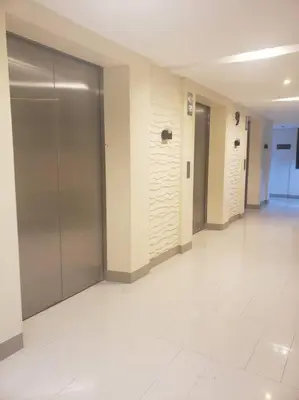 a hallway of a building with doors and a tile floor at JoVis Place Staycation near MOA(Wifi & Netflix) in Manila