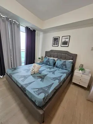 a bedroom with a bed with a blue comforter at Azure Urban Resort Residences in Manila