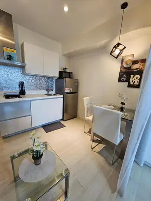 a kitchen and living room with a table and a counter at Azure Urban Resort Residences in Manila