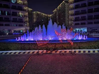 a water fountain in a city at night at Azure Urban Resort Residences in Manila