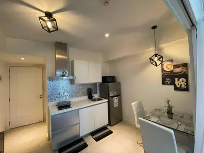 a small kitchen with a table and a refrigerator at Azure Urban Resort Residences in Manila