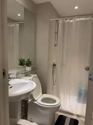 a white bathroom with a toilet and a sink at Azure Urban Resort Residences in Manila