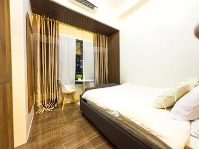 a bedroom with a bed and a table and a window at 1BR Makati, Air Residences M002 in Manila