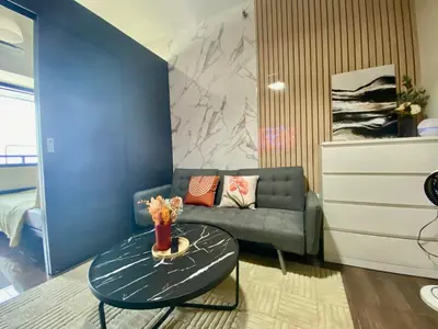 a living room with a couch and a table at Air Residence-Sunset & City Views Await in Manila
