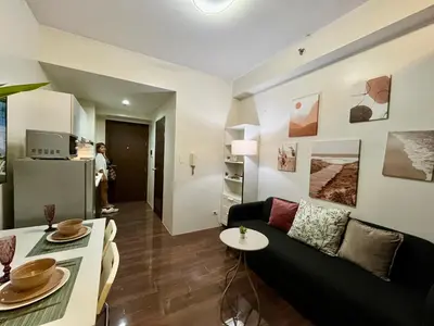 a living room with a couch and a table at Air Residence-Sunset & City Views Await in Manila