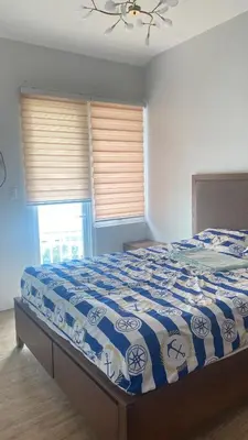 a bedroom with a bed with a blue and white comforter at Staycation One bedroom in Manila