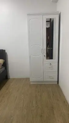 a white cabinet in a room with a wooden floor at Staycation One bedroom in Manila