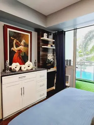 a bedroom with a painting of a woman playing a violin at Azure Paranaque near Airport in Manila