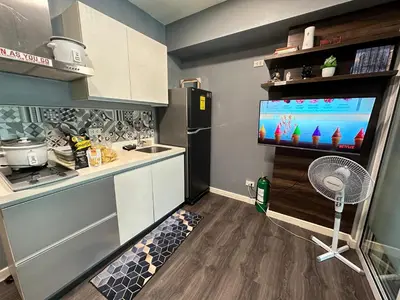 a kitchen with a refrigerator and a tv in it at Azure Paranaque near Airport in Manila