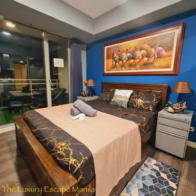 a bedroom with a bed and a painting on the wall at Azure Paranaque near Airport in Manila